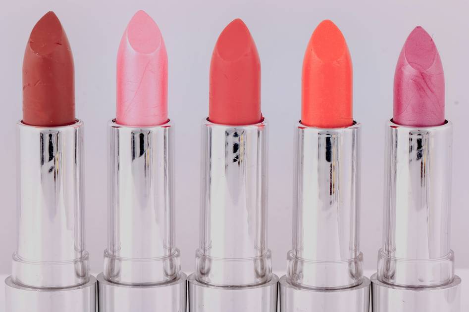 Flat lay of assorted lip crayons in rose and nude shades with soft lighting